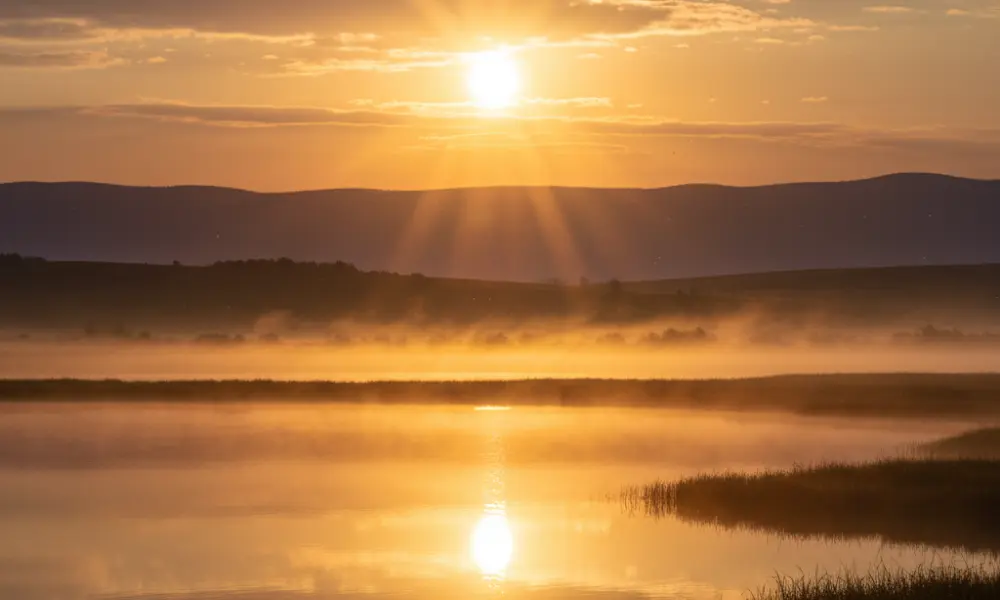 Horizonte iluminado pelo nascer do sol simbolizando renovação através da presença